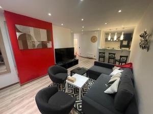 a living room with a black couch and chairs at Spacieux T2 avec parking à 200 m Cathédrale in Chartres
