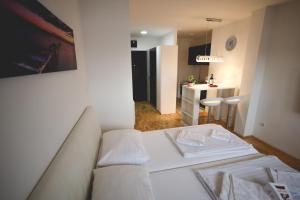 Il comprend un salon avec un canapé blanc et une cuisine. dans l'établissement Apartman Lux, à Nova Pazova