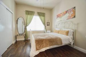 1 dormitorio con cama, espejo y silla en Historic Charm with Parking in Center of Midtown en Sacramento