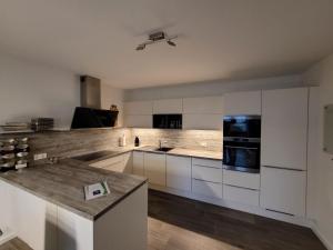 a kitchen with white cabinets and a counter top at Leipziger Neuseenland Apartment in Markkleeberg