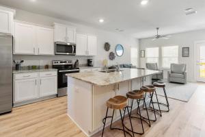 a kitchen with white cabinets and bar stools at Serenity Salty Intentions At 14334 Gardenglen Drive in Pensacola