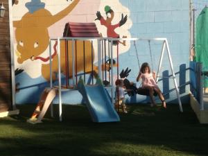 una mujer y un niño jugando en un patio de recreo en Bungalow Perotonar Ideal Para Familia Con Niños en La Puebla de Cazalla