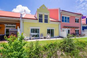 een kleurrijk huis met stoelen in een tuin bij Banana Bay 6047 By Pkrm in Pensacola