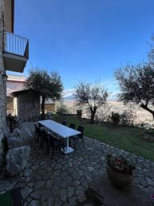 un patio in pietra con tavolo e sedie in un cortile di Casale di lusso panoramico a Lettere