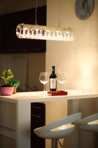 - une bouteille de vin et deux verres à vin sur un comptoir dans l'établissement Apartman Lux, à Nova Pazova