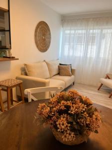sala de estar con sofá y mesa con una cesta de flores en NOVO Mar Doce Lar Pé na Areia, en Balneário Camboriú
