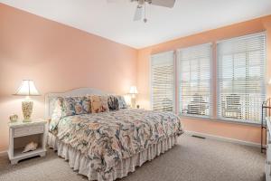 a bedroom with a bed and two windows at Bear Trap Dunes - 60E October Glory in Ocean View +28 photos