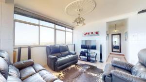a living room with a couch and a chair and a television at Shangri-La Penthouse View in Kingsburgh