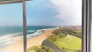 a view of a beach from a window at Shangri-La Penthouse View in Kingsburgh