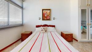 a bedroom with a large bed with red and white stripes at Shangri-La Penthouse View in Kingsburgh