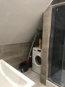 a bathroom with a washing machine and a washer at Apartament, noclegi na doby - Raczki k. Suwałk in Raczki