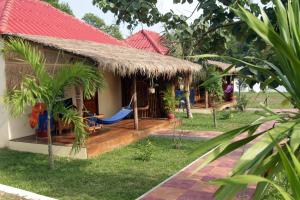 una piccola casa con un'amaca all'esterno di Sunset Lounge a Sihanoukville