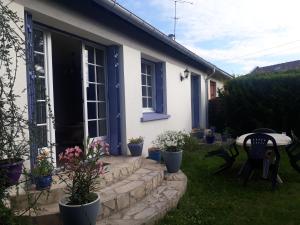 een wit huis met blauwe ramen en een patio bij Paris Magic - Villepinte Exhibition Center in Sevran