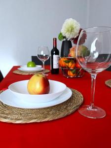 a red table with a plate of fruit and wine glasses at Calle Mora De Rubielos with Free Private Underground Parking in Valencia