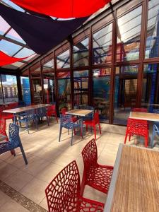 un restaurante con sillas rojas, mesas y ventanas en Lovely 4 berth static caravan, Marine Holiday Park, Rhyl, Wales, en Rhyl