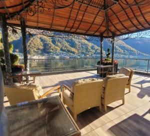 een patio met stoelen en tafels en uitzicht op een berg bij La Farfalla in Brusino Arsizio