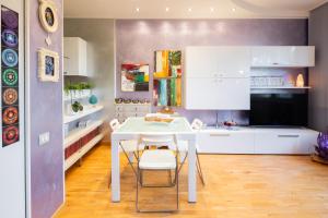 a white kitchen with a white table and chairs at Appartamento a Modena, comodo a tutti i servizi in Modena