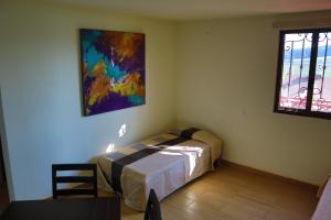 um quarto com uma cama e um quadro na parede em MASIA ARAMENI em Umecuaro