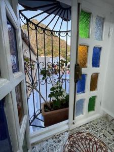 an open door with a potted plant on a balcony at Coco Chawen in Chefchaouen