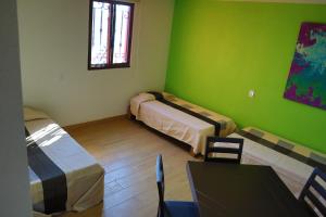 a room with two beds and a table and a window at MASIA ARAMENI in Umecuaro