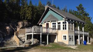 a large house with a balcony on a hill at Le Refuge de mon père in Sacré-Coeur-Saguenay
