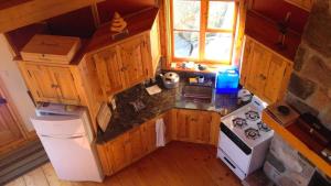 an overhead view of a small kitchen with wooden cabinets at Le Refuge de mon père in Sacré-Coeur-Saguenay