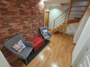 a living room with two chairs and a brick wall at Room Dream Beato in Lisbon