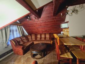 a living room with a couch and a table at Villa Rusalka in Vysoke Tatry - Tatranska Kotlina