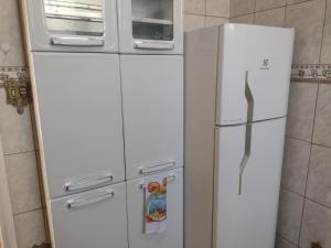 einen weißen Kühlschrank mit einer Mikrowelle darüber in der Unterkunft Meu Cantinho E in Guaratinguetá