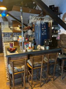 a kitchen with a counter with chairs at a bar at Vila Milica Poganovo in Poganovo +18 photos