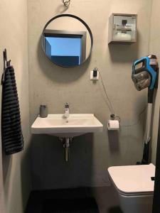 La salle de bains est pourvue d'un lavabo, d'un miroir et de toilettes. dans l'établissement BOTKa apartmán, à Tatranska Strba