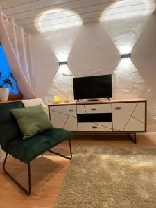 ein Wohnzimmer mit einem TV und einem Stuhl in der Unterkunft Apartment Balingen City in Balingen