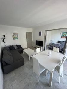een woonkamer met een bank en een tafel bij Seafront - beautiful flat with aircon and comfortable loggia in Vallauris