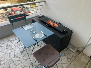 een tafel en een grill met een tafel en stoelen bij Seafront - beautiful flat with aircon and comfortable loggia in Vallauris