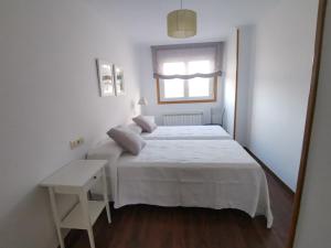 ポンテベドラにあるApartamento Cómodo y Céntricoの白いベッドルーム(ベッド1台、窓付)