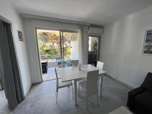 una sala da pranzo con tavolo e sedie bianchi di Seafront - beautiful flat with aircon and comfortable loggia a Vallauris