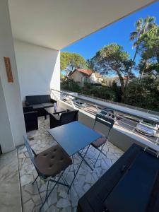 een kamer met een tafel en stoelen op een balkon bij Seafront - beautiful flat with aircon and comfortable loggia in Vallauris