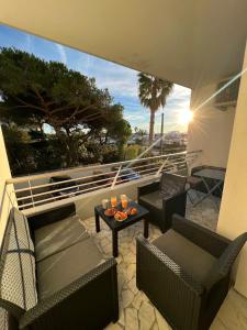 een patio met stoelen en een tafel op een balkon bij Seafront - beautiful flat with aircon and comfortable loggia in Vallauris