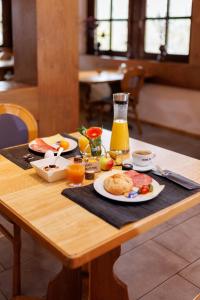 a table with breakfast foods and orange juice on it at Naturhotel Blaubach in Blaubach
