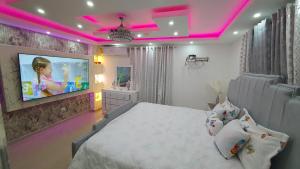 ein Schlafzimmer mit einem großen Bett und einem TV an der Wand in der Unterkunft Hermoso Apartamento En Cerro Alto Santiago in Santiago de los Caballeros