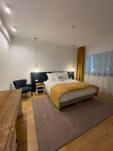 1 dormitorio con 1 cama extragrande y 1 silla en Hanul cu Sălcii en Călimăneşti