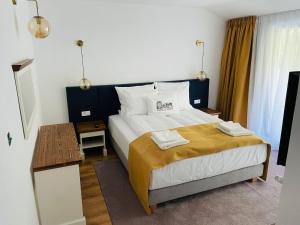 una camera da letto con un letto con due asciugamani sopra di Hanul cu Sălcii a Călimăneşti