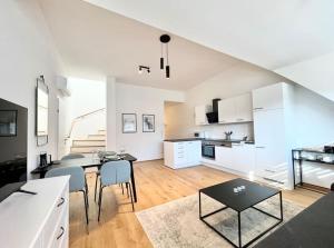 a kitchen and living room with a table and chairs at OrestaLiving - Penthouse in 1020 in Vienna