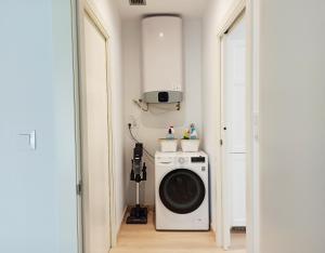 een wasruimte met een wasmachine in de kamer bij A Casa da Compañía in Monforte de Lemos