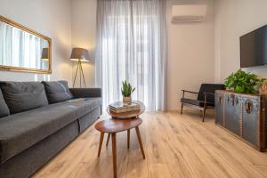 un soggiorno con divano e tavolo di RelaisApartments MERCEDE - Extraordinary Hospitality ad Alghero