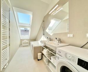 a laundry room with two sinks and a washing machine at OrestaLiving - Penthouse in 1020 in Vienna +16 photos