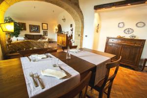 uma sala de jantar com uma mesa e uma sala de estar em La Casa Degli Archi em Pitigliano