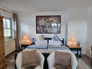 a bedroom with a bed and two chairs at Appartement Bergsee SUN - am Wildsee - atemberaubende Aussicht in Seefeld in Tirol +42 photos