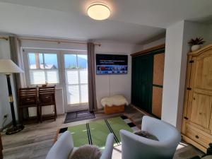 uma sala de estar com cadeiras brancas e uma mesa de vidro em Appartement Bergsee SUN - direkt am See - Sonnenbalkon em Seefeld in Tirol
