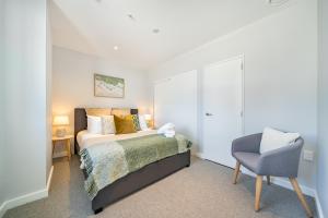 a bedroom with a bed and a chair at Hutt Central in Lower Hutt